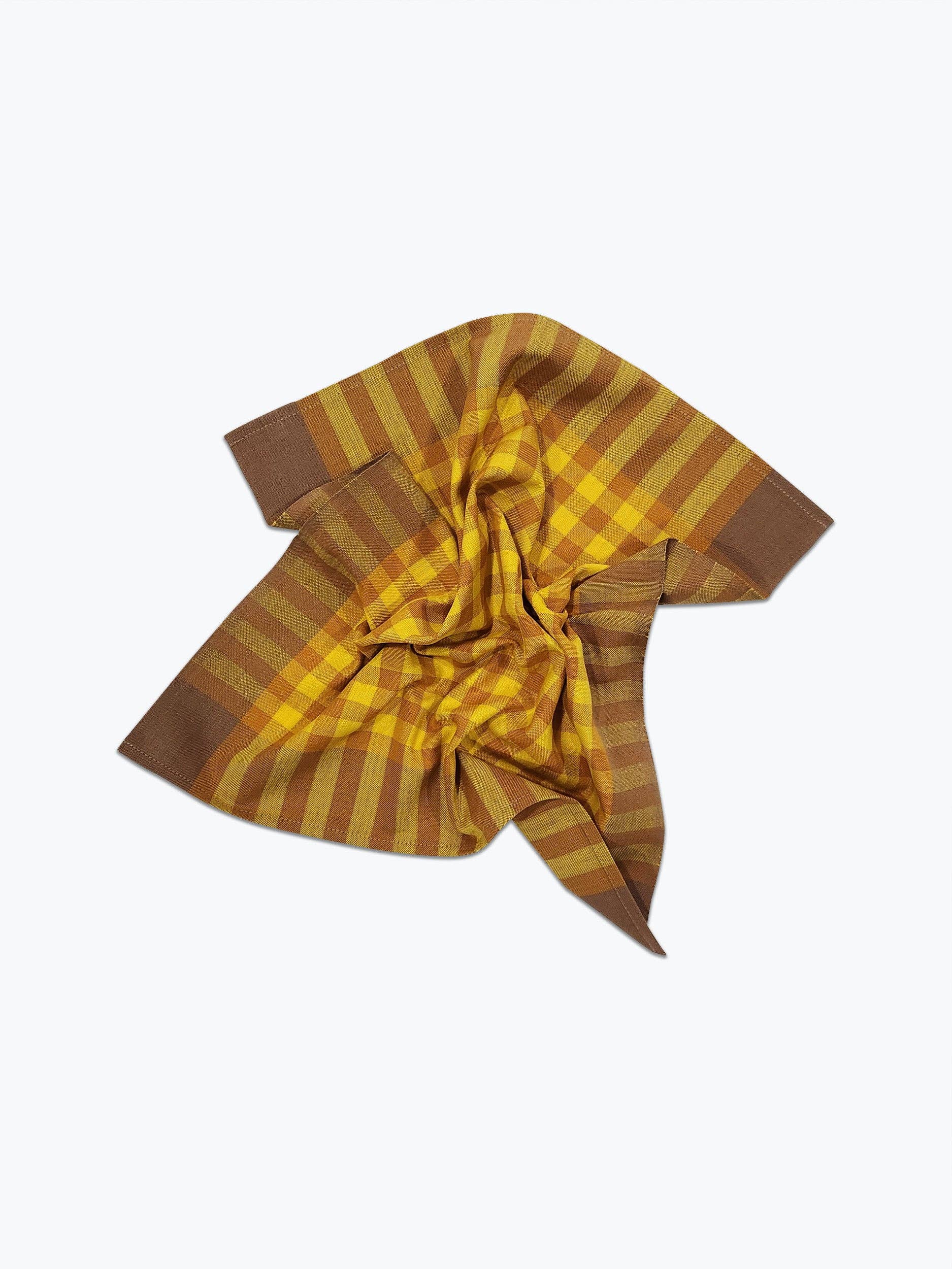 A scrunched handwoven plaid napkin with brown and yellow pattern displayed on a white background