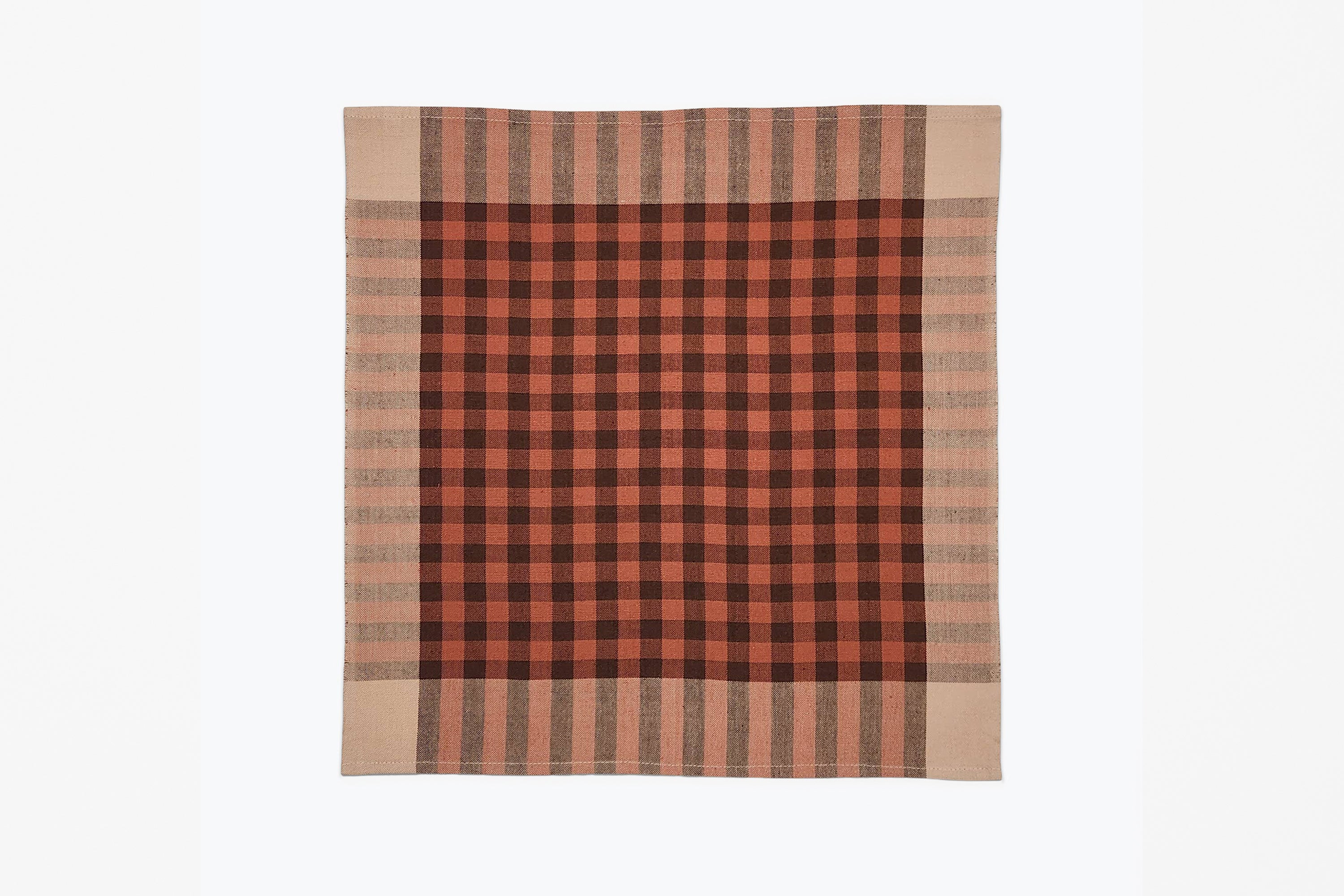 A square woven plaid napkin with a red, brown, and beige detail, displayed flat against a plain white background.