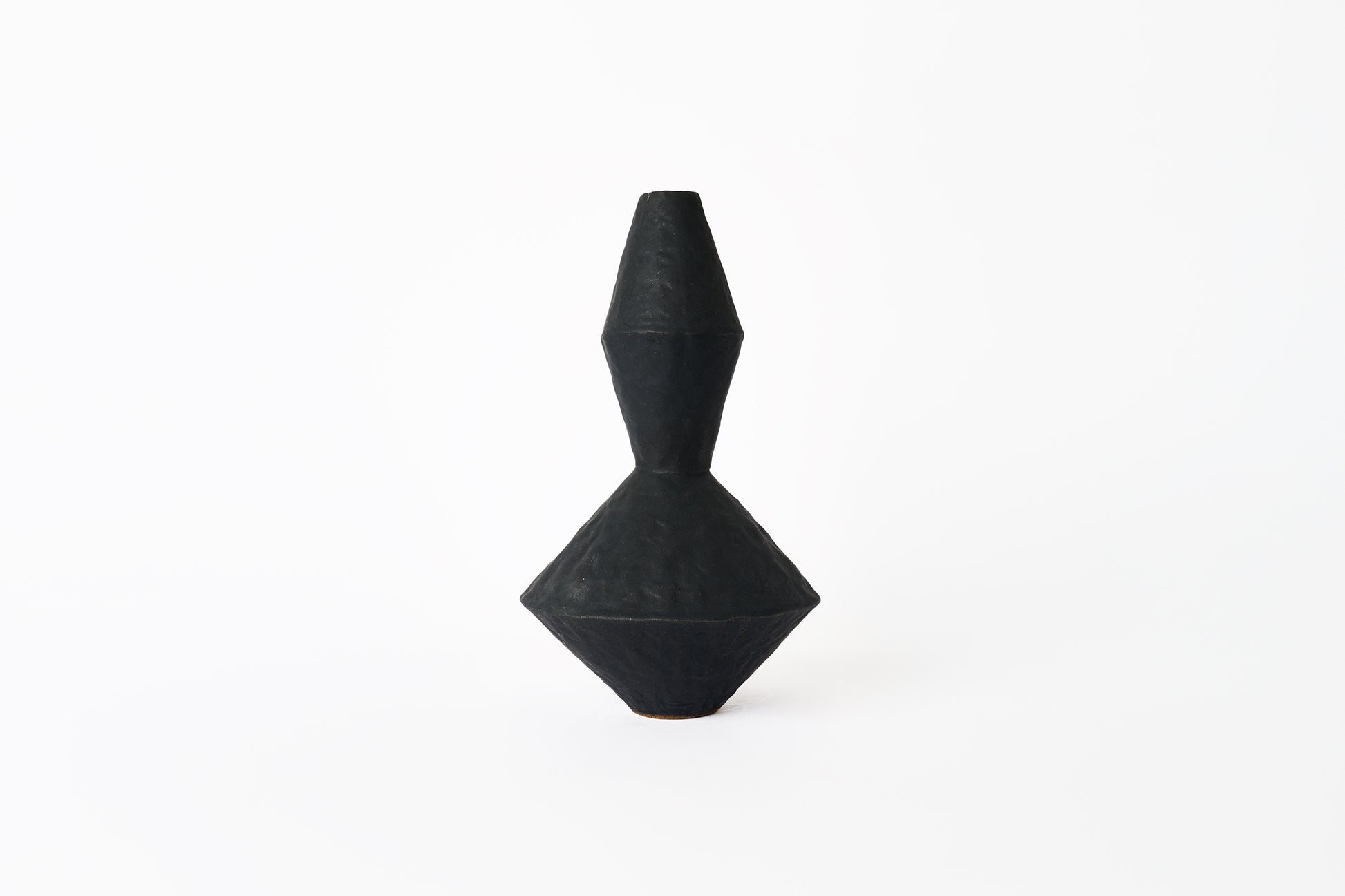 Black geometric sculptural vase on a white background