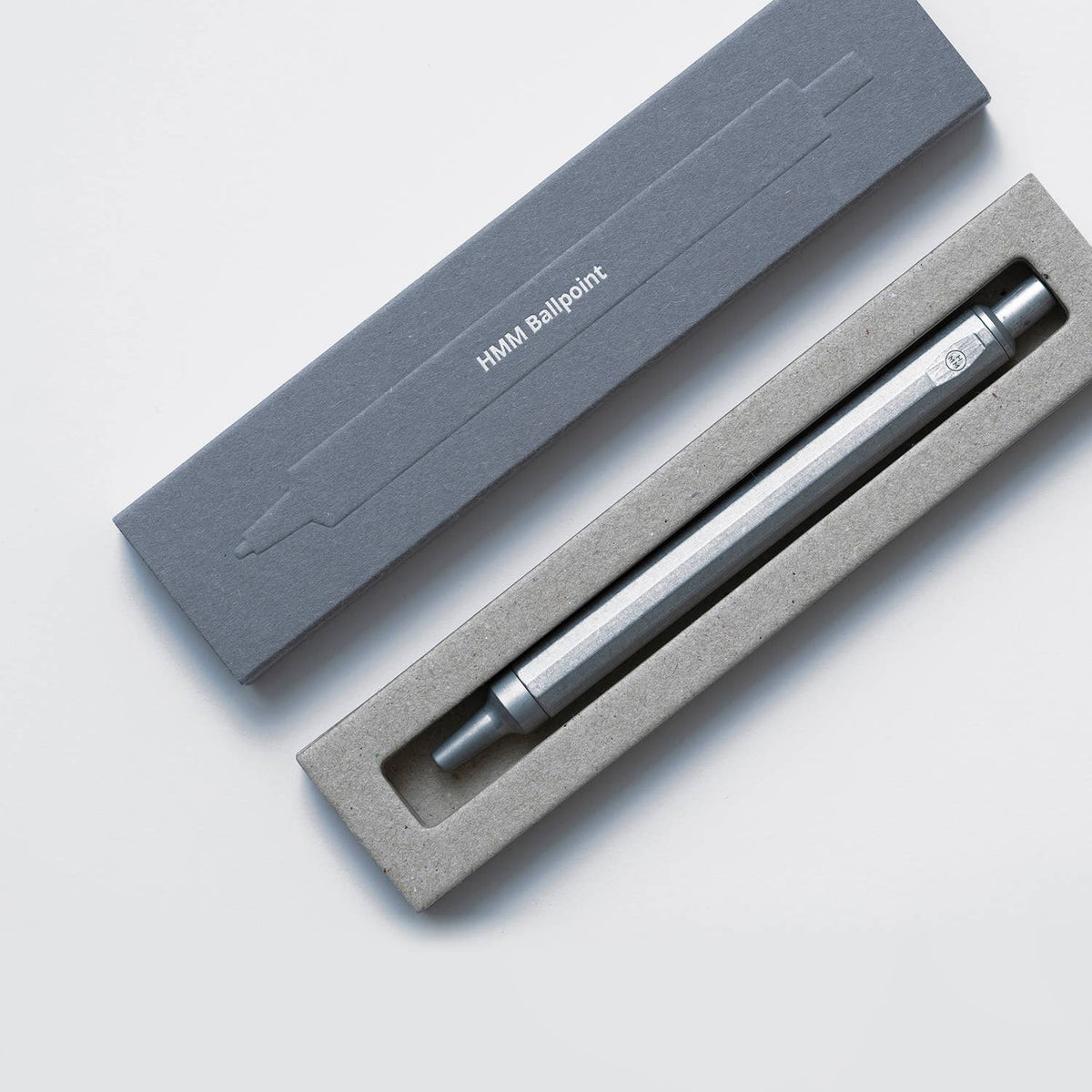 Silver ballpoint pen in a gray box on a light gray background