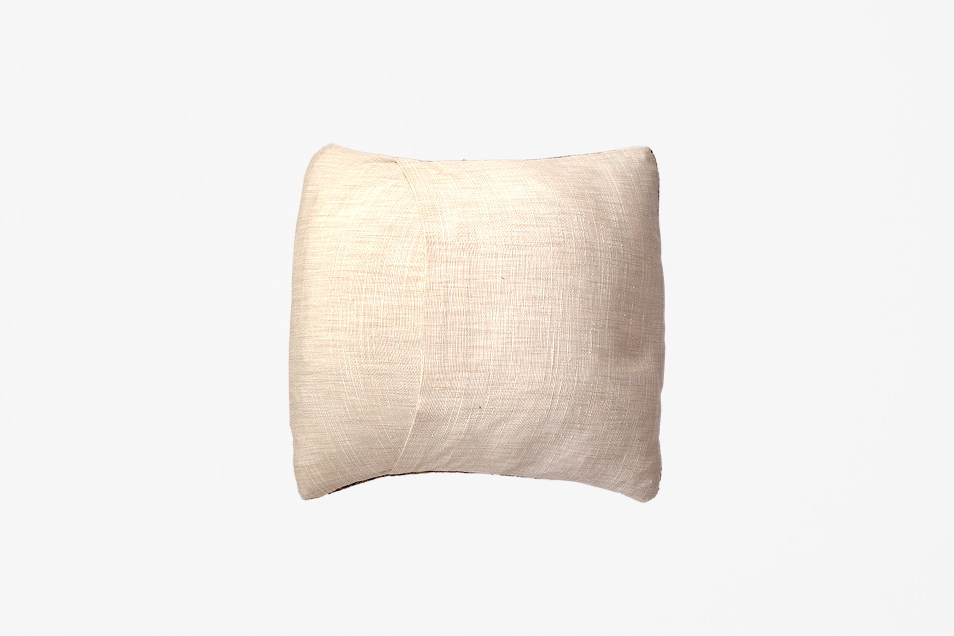 The linen backing of an extra small handwoven tapestry pillow against a white background.