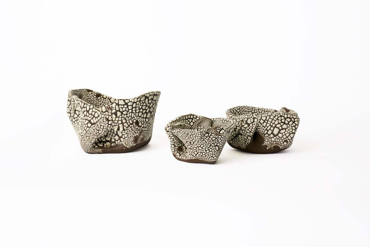 Hand-built organically-shaped planters in three different sizes on a white background.