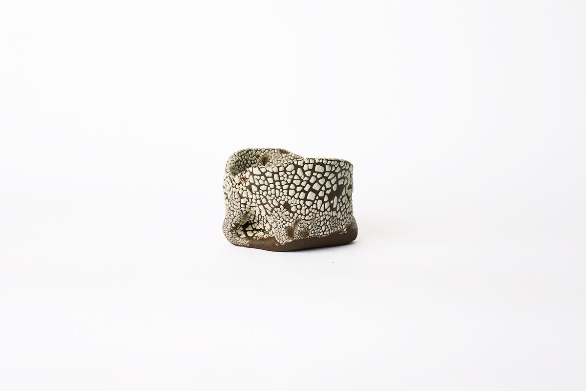 A large hand-built brown stoneware planter with dotted white textured glaze surface on a white background.
