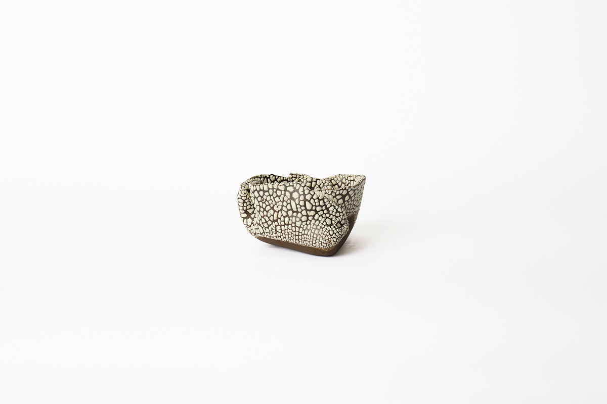 A medium hand-built brown stoneware planter with dotted white textured glaze surface on a white background.