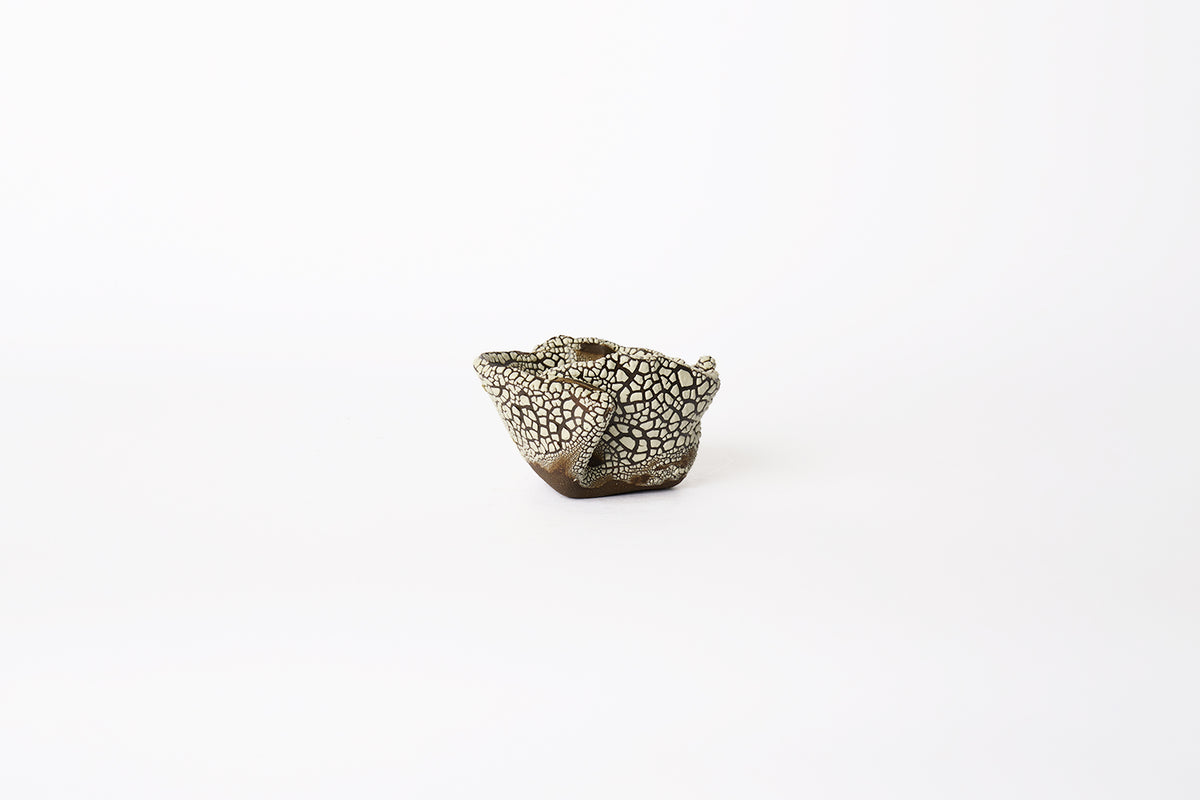 A small hand-built brown stoneware planter with dotted white textured glaze surface on a white background.